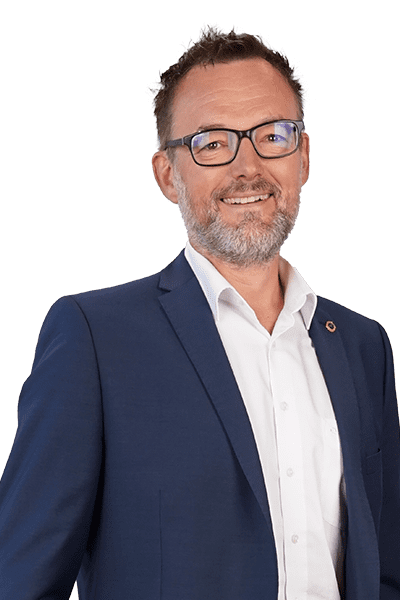 Geschäftsführer Marc Wischmann, lächelnd mit weißem Hemd und blauem Jackett