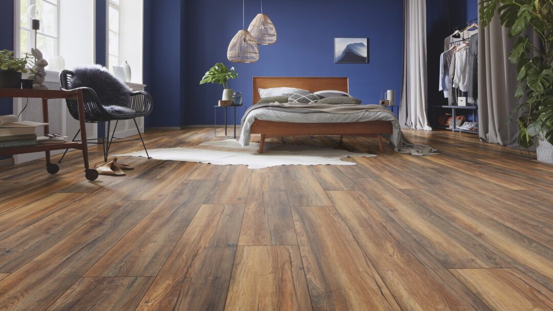 Hochwertiges Laminat ziert den Boden eines eleganten Schlafzimmers mit dunkelblauen Wänden als Kontrast