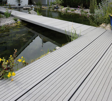 Idyllische WPC Terrasse, die über einen Teich führt