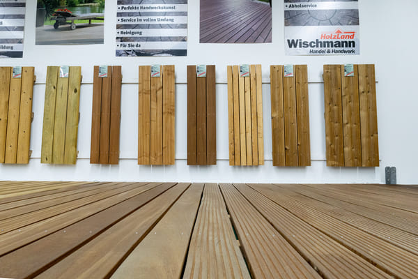Ausstellung Holzterrassen: Eine Große Auswahl an Holzterrassendielen, die auf dem Boden und an der Wand montiert sind