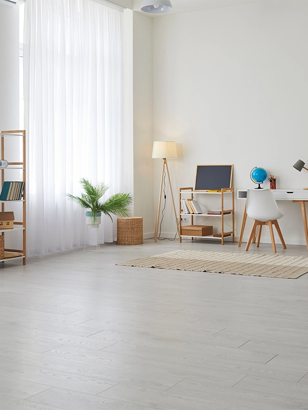 In einer Essener Wohnung ist heller Laminatboden verlegt, im Hintergrund stehen Regale ein Tisch une ein Pflanze